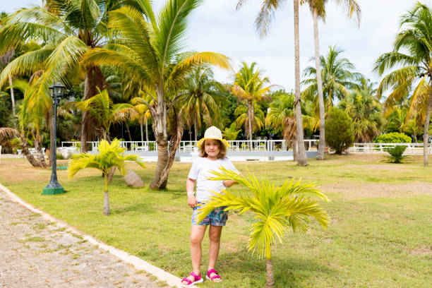 istock child in a hat posing on a background of palm trees 1333743813