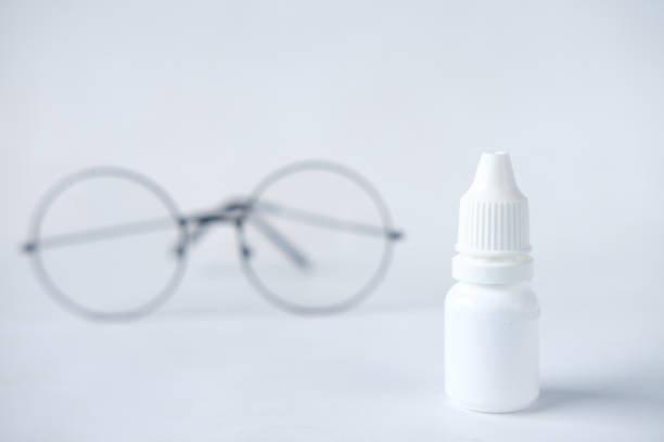 istock close up of eye drop bottle and eyeglass on white, 1333744725