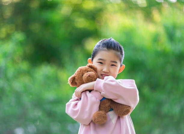 istock Cute Little Girl Embracing Teddy Bear 1333747447