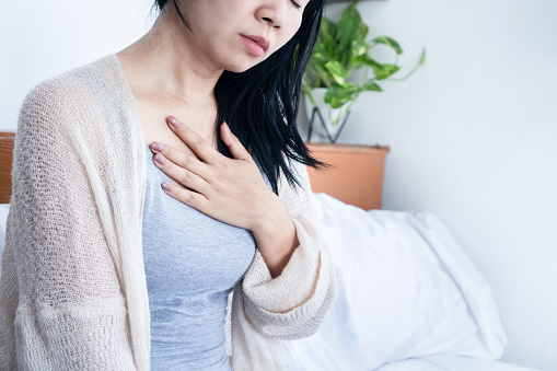 Mujer asiática con dolor en el pecho, dificultad para respirar photo