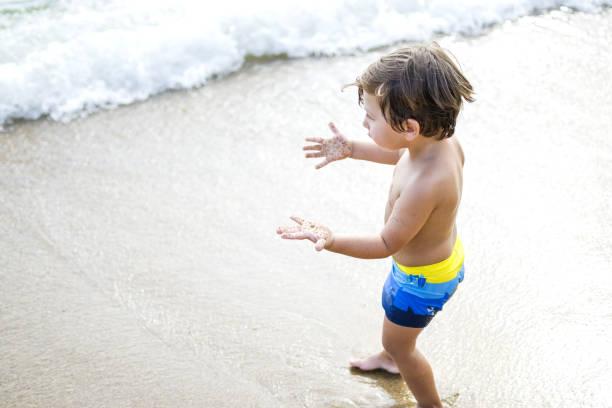 istock Happy child boy enjoying to beach 1333749736