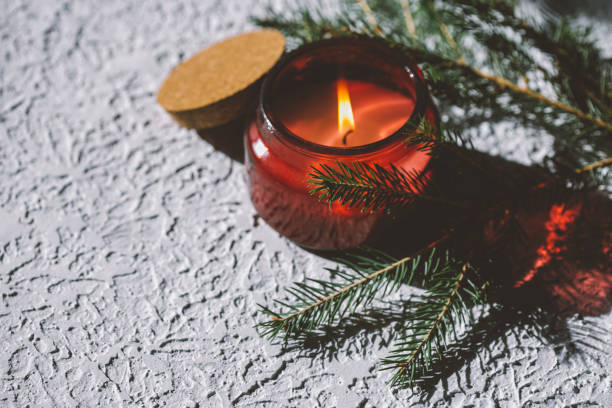 istock a red burning candle and a fir tree 1333750824
