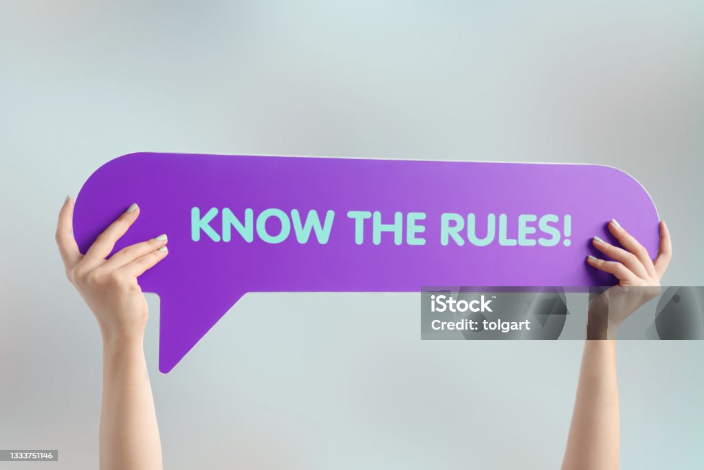 Know the rules! Hand holding speech bubble with know the rules word Rules Stock Photo