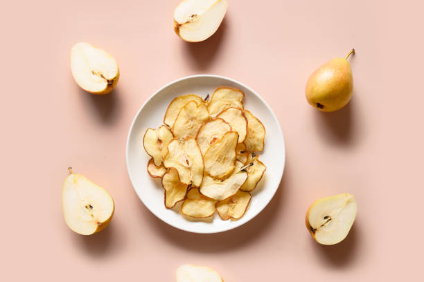 chips de pera de frutas em um fundo bege. sobremesa vegana sem açúcar. vista superior. - dehydrated fruit - fotografias e filmes do acervo