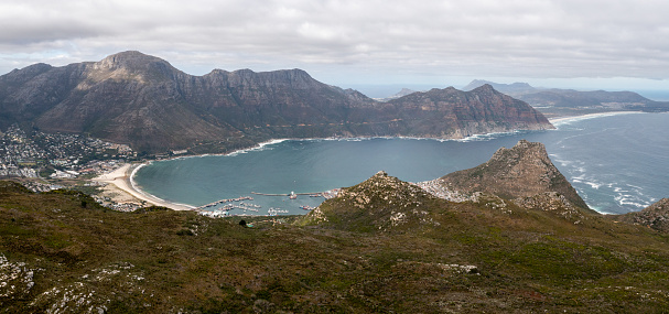 Stunning panoramic photo of the coastal town of Hout bay in Cape Town. Aerial view over a dramatic seascape off the coast of South Africa.