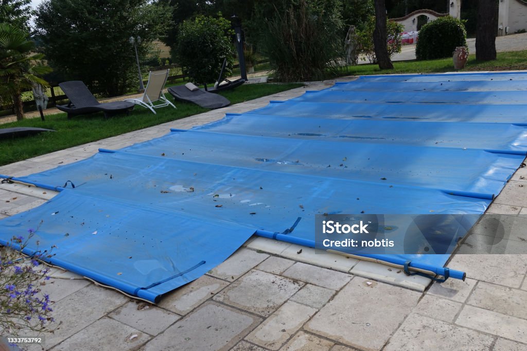 Outdoor swimming pool covered due to bad weather Summer season Holiday resort Outdoor swimming pool covered due to bad weather Summer season  Holiday resort Tarpaulin Stock Photo
