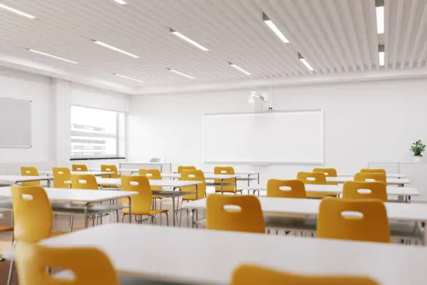 Interior of an empty modern classroom with interactive whiteboard and chairs.