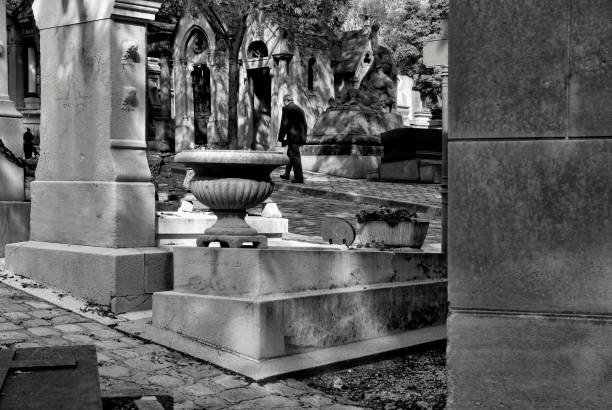 Senior man walks alone in cemetery pere lachaise paris france september 27 2006 - unknown elderly man walks alone in the cemetery pere lachaise in central paris. urban dictionary stock pictures, royalty-free photos & images