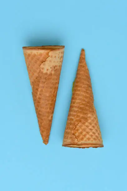 Two Ice Cream Cones on a blue background. Flat lay minimalist styling.