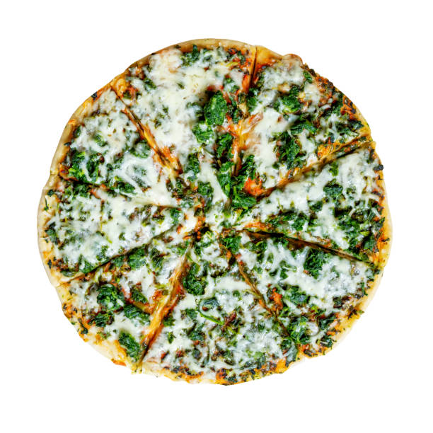 Sliced pizza with tomatoes, cheese, and fresh green leaves floating against a green background. Isolated