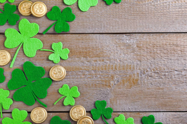istock Flat lay composition with clover leaves and gold coins on wooden table, space for text. St. Patrick's Day celebration 1333761308