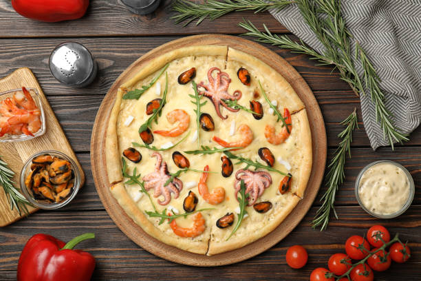 istock Delicious seafood pizza on wooden table, flat lay 1333761880