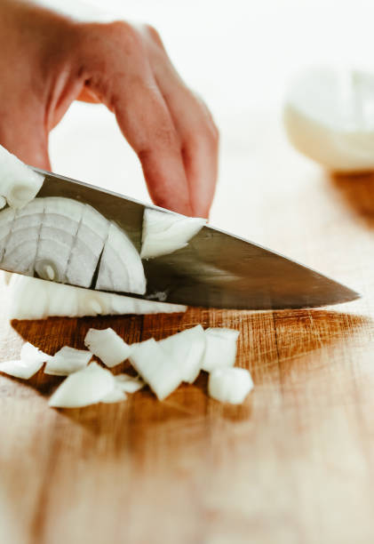 istock Chefs woman hands chopping onion on wooden board 1333761991