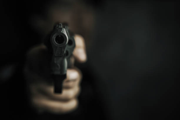 istock Muzzle of gun in man's hand is pointed at camera. 1333762529