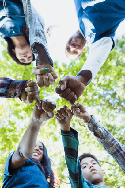 istock Low angle view diverse volunteers showing unity with fist bump 1333762883