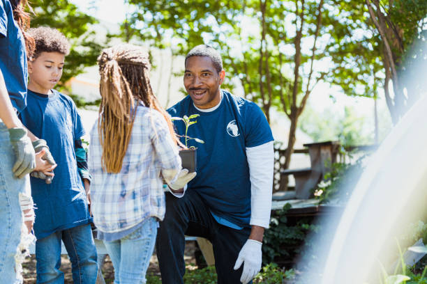 istock Male botanist engages with elementary age girl on field trip 1333762936