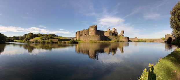 Caerphilly, Wales - August 2017: Panoramic view of  Caerphilly Castle with reflection on the still waters of the moat. The Castle is the second largest in the UK after Windsor Castle