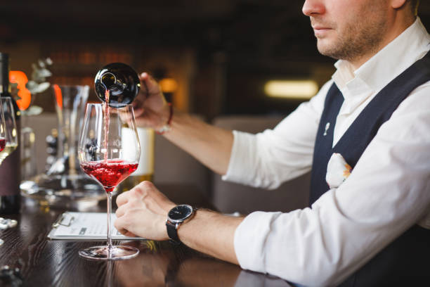 istock Sommelier pours red wine into glass at table in restaurant 1333765397