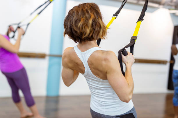 Strong Woman Exercising With TRX suspension ripl fitness