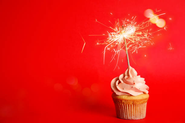 istock Birthday cupcake with sparkler on red background. Space for text 1333766619