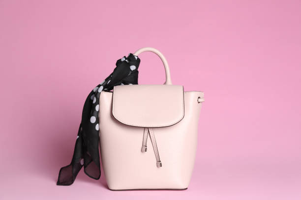 istock Stylish woman's backpack and scarf on light pink background 1333768096