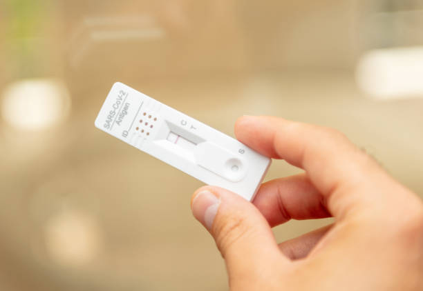 istock Man hand holding Covid 19 negative result self test. 1333769520