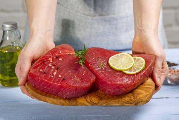 filete de atún crudo con eneldo, limón y especias en tabla de cortar de aceituna - tuna tuna steak raw freshness fotografías e imágenes de stock