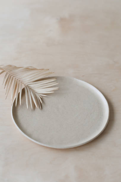 istock Ceramic plate on a wooden table top view. minimalist handmade ceramic tableware and pottery 1333771374