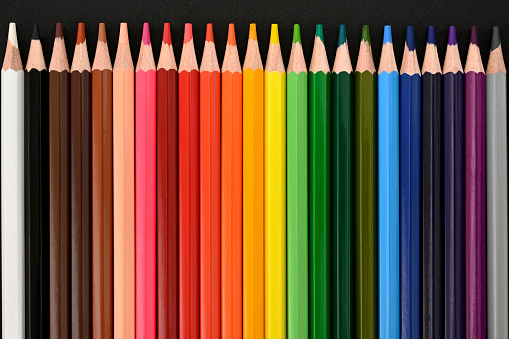 Crayons. Colored pencils on black cardboard background. Top view. Education concept. High quality photo