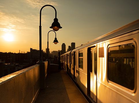 Outdoor subway station during sunset in Queens, New York City.
