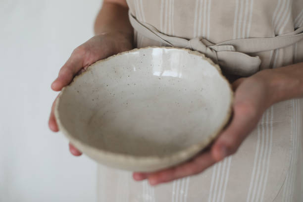 istock Hands holding ceramic bowl isolated on white background. Handmade ceramic tableware and pottery 1333772803