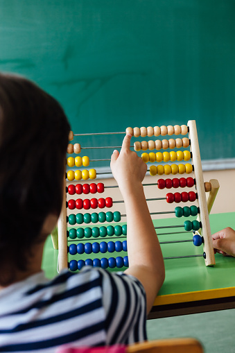 Child working with abacus in the classroom.