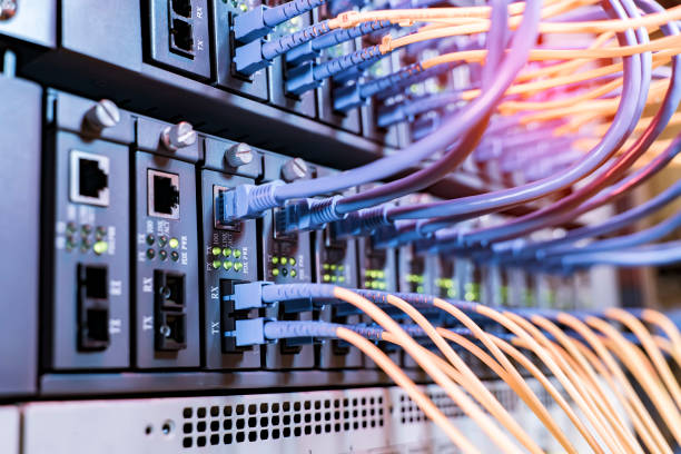istock Fiber Optical cables connected to an optic ports and Network cables connected to ethernet ports 1333775715