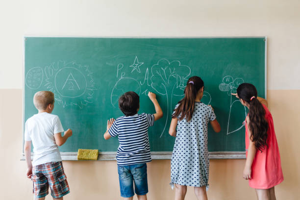 istock Children Writing On Blackboard At School 1333776298