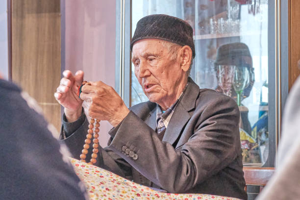 istock Mullah talking counting rosary at rural house. 1333776454