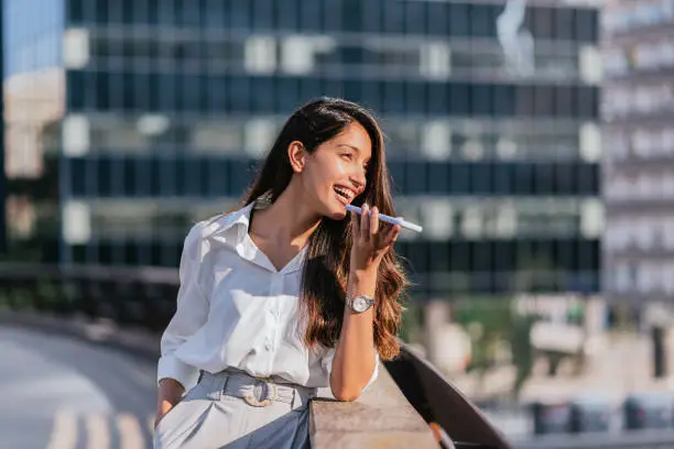 Photo of Indian business woman sending voice message with her phone