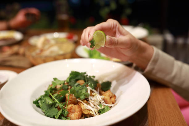 istock Person squeezes lemon juice on shrimp salad 1333780731