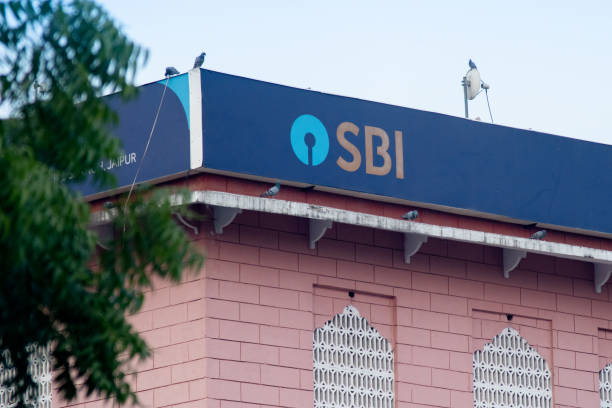 Blue state bank of India SBI board hoarding on top of pink building showing india's largest public sector bank under which PSU banks are being consolidated stock photo