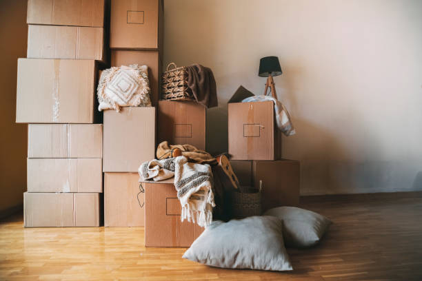 Stack of cardboard boxes and decorative house objects in new apartment. Moving day. Stack of cardboard boxes and decorative house objects in new apartment. Moving day. Moving in concept. Real estate concept. Copy space. unpacking stock pictures, royalty-free photos & images