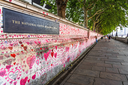 London, UK - A sign on the National Covid Memorial Wall, decorated with hundreds of thousands of red hearts and personal dedications to the victims of the Covid-19 pandemic in the UK. The wall is located on the South Bank of the Thames in central London.
