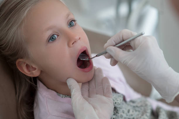 istock Pediadontist examining teeth of her cute small patient 1333784832