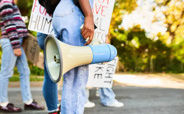 Photo of Woman standing with a megaphone during a women's rights day march