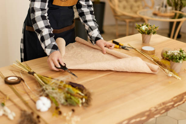 istock female hand cutting craft paper on table. 1333790716