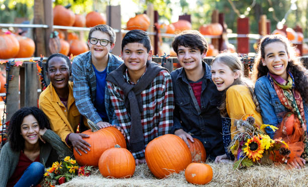 istock Boy with down syndrome, group of friends at pumpkin patch 1333794575