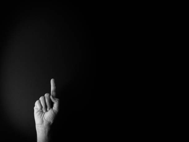 istock Black and white image of hand demonstrating sign language number one with empty copy space 1333796415