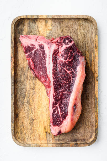 raw fresh beef t-bone steak drya aged cut, on wooden tray, on white stone  background, top view flat lay - veal t bone steak raw steak imagens e fotografias de stock