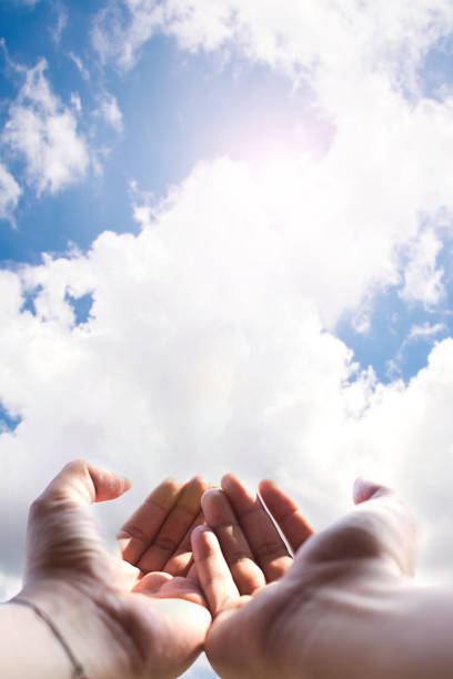 Soft focus of hands of human praying on blue sky background with sunlight,Spirituality with believe and religion Soft focus of hands of human praying on blue sky background with sunlight,Spirituality with believe and religion christian social union photos stock pictures, royalty-free photos & images