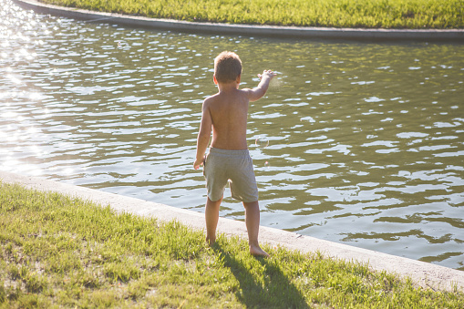 Photo of a young boy jumping into the lake.