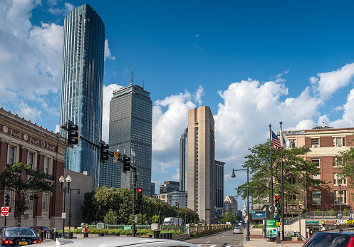 This captivating image features a modern cityscape with sleek, reflective glass windows that shimmer in the urban sunlight. The architecture is a testament to contemporary design, creating a striking contrast against the city's backdrop.