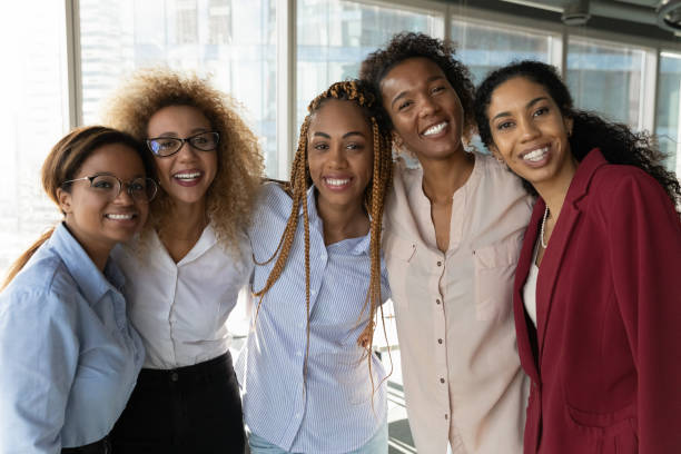 Happy millennial diverse biracial female employees looking at camera. Portrait of smiling beautiful successful young african american business women in formal wear posing in modern workplace. Happy millennial diverse biracial female employees looking at camera. african american ethnicity stock pictures, royalty-free photos & images